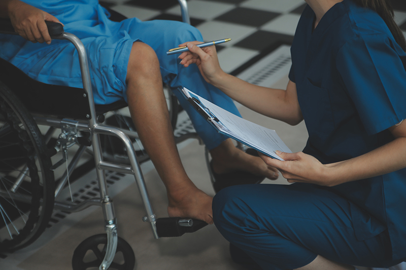 Young physiotherapist exercising with elder disabled person